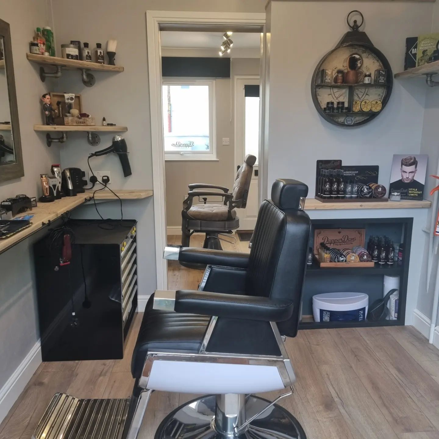 Inside The Garage: a black barber chair, shelves and a mirror