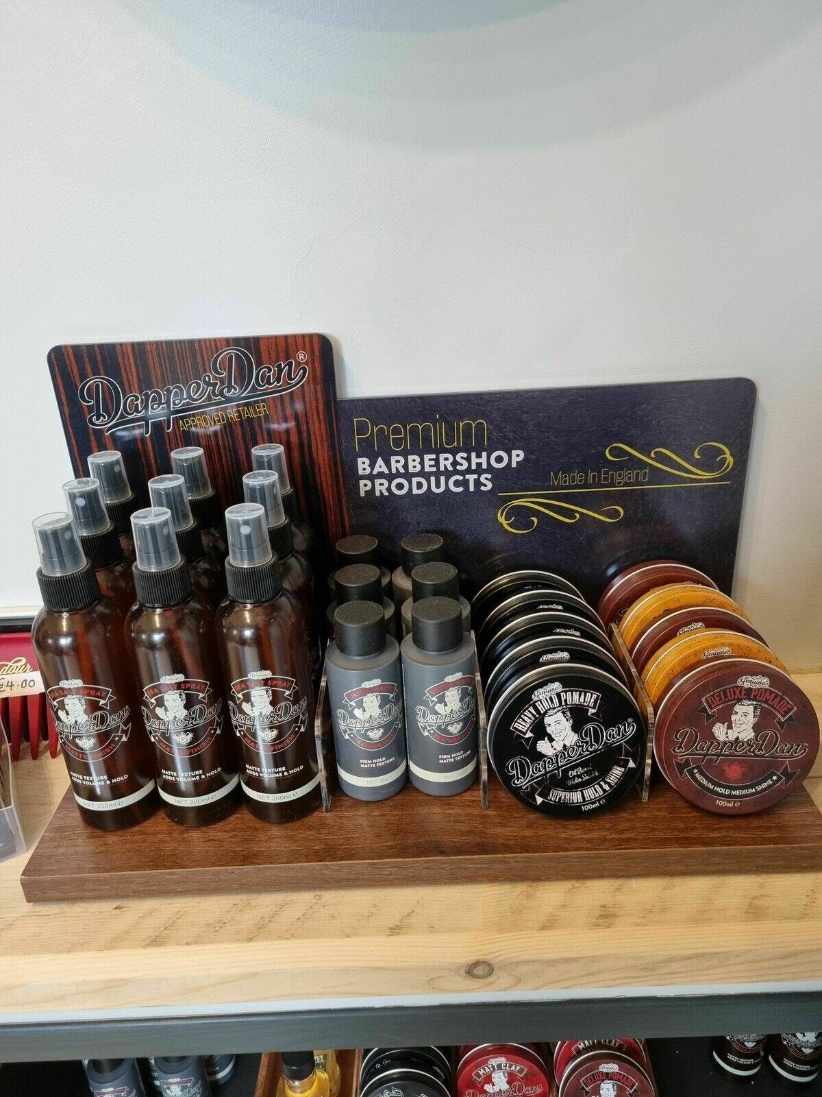 Premium barbershop products lined up on a wooden shelf