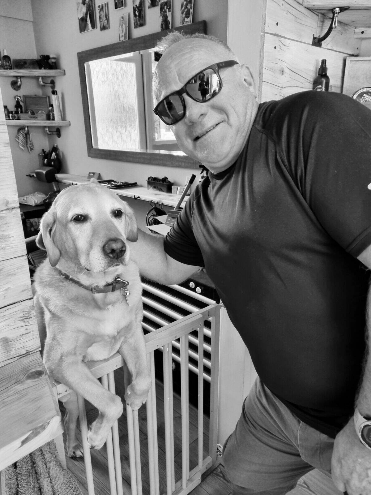 A customer in sunglasses grinning at the stair gate, black and white