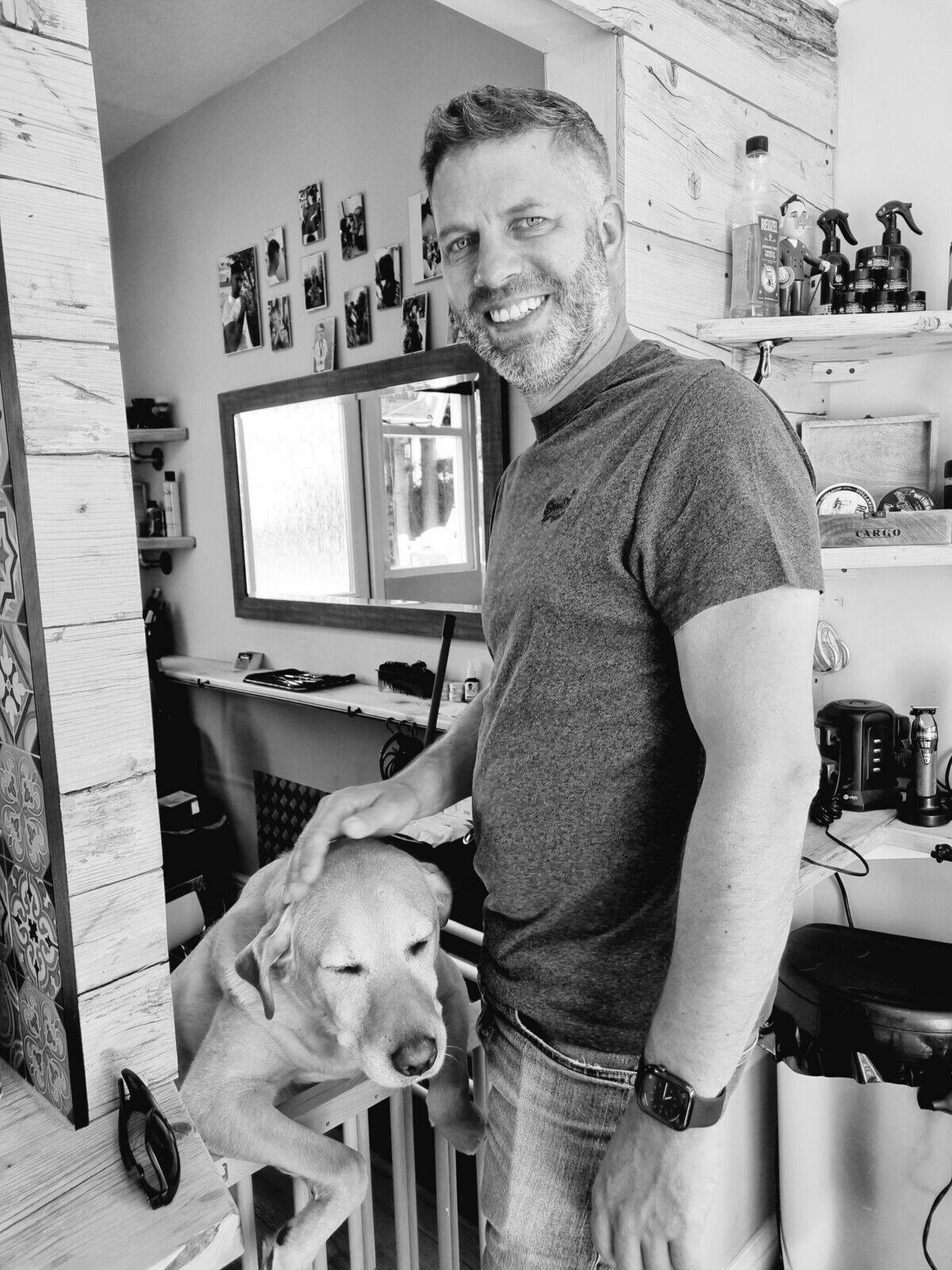 A customer in a grey T-shirt standing by the mirror, black and white