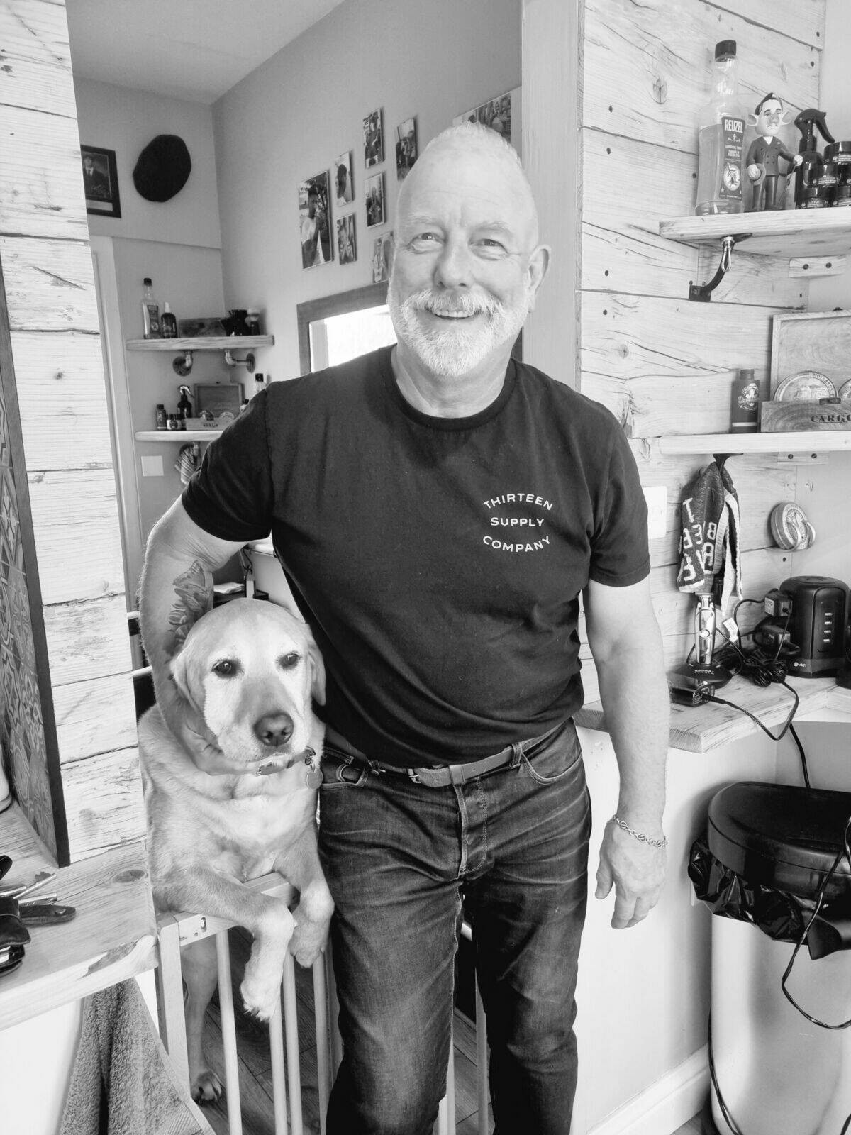 A bearded customer smiling in the shop, black and white