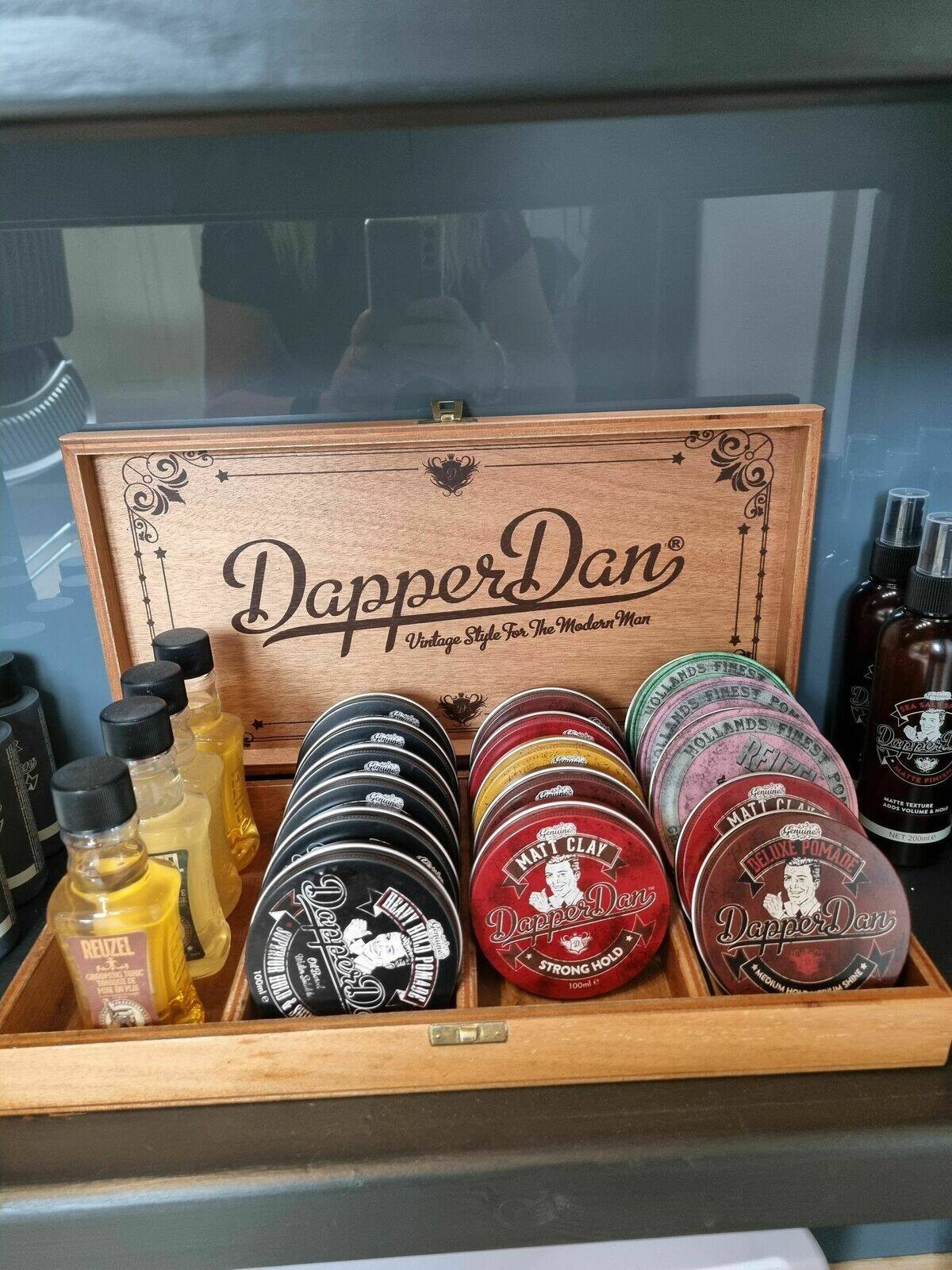 A wooden display box of hair pomades and beard oils