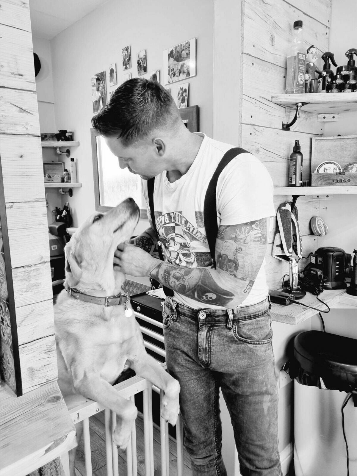 A tattooed customer in braces after his cut, black and white